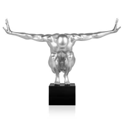 Scultura in resina grigio chiaro metallizzato raffigurante un uomo in equilibrio in posizione accovacciata su un piedistallo