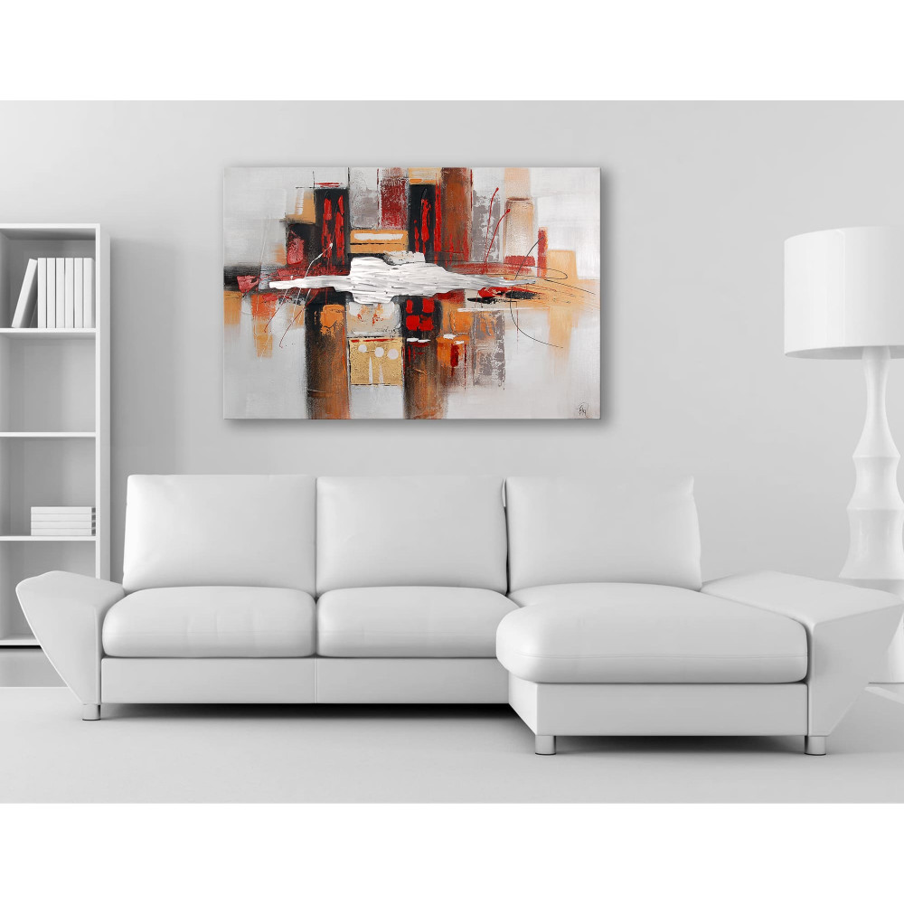 dipinto astratto realizzato a mano nei toni del rosso e del bianco su tela con inserti metallici posizionato in salotto con divano bianco