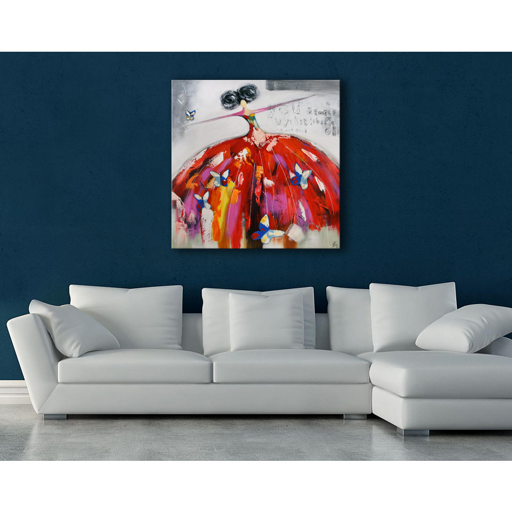 Quadro dipinto a mano ritraente donna con vestito vaporoso rosso e farfalle blu intorno posizionato in salotto con parete blu e divano bianco