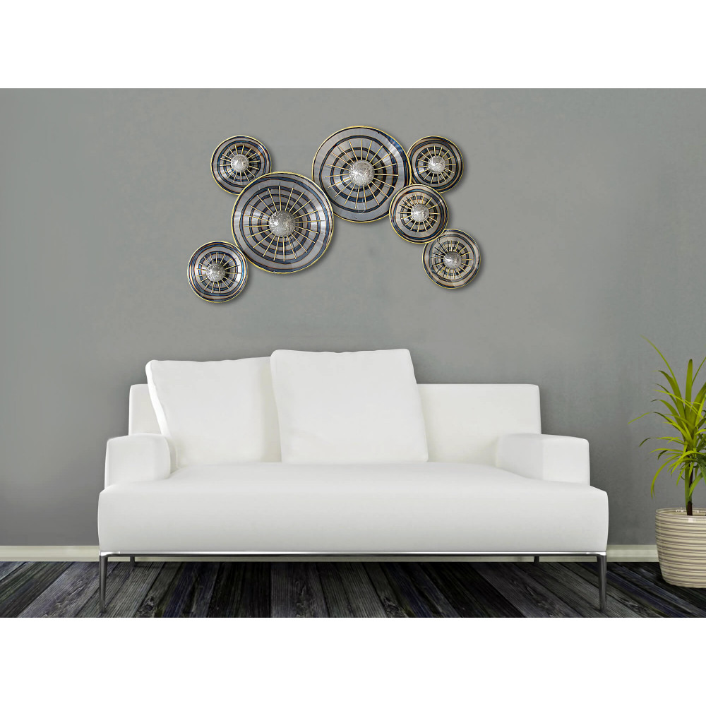 Ambiente living moderno decorato con scultura in metallo a parete con tema astratto