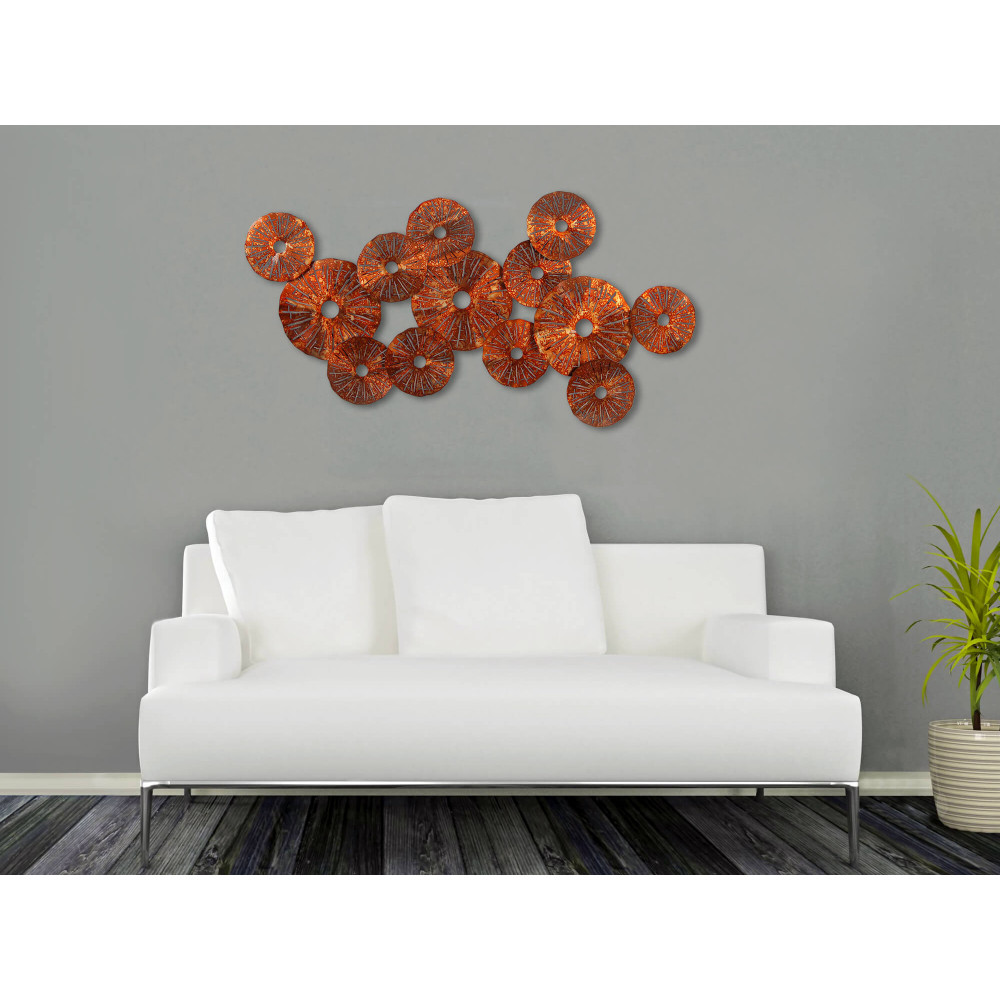 Ambiente living moderno decorato con quadro in metallo con dischi color rame sovrapposti