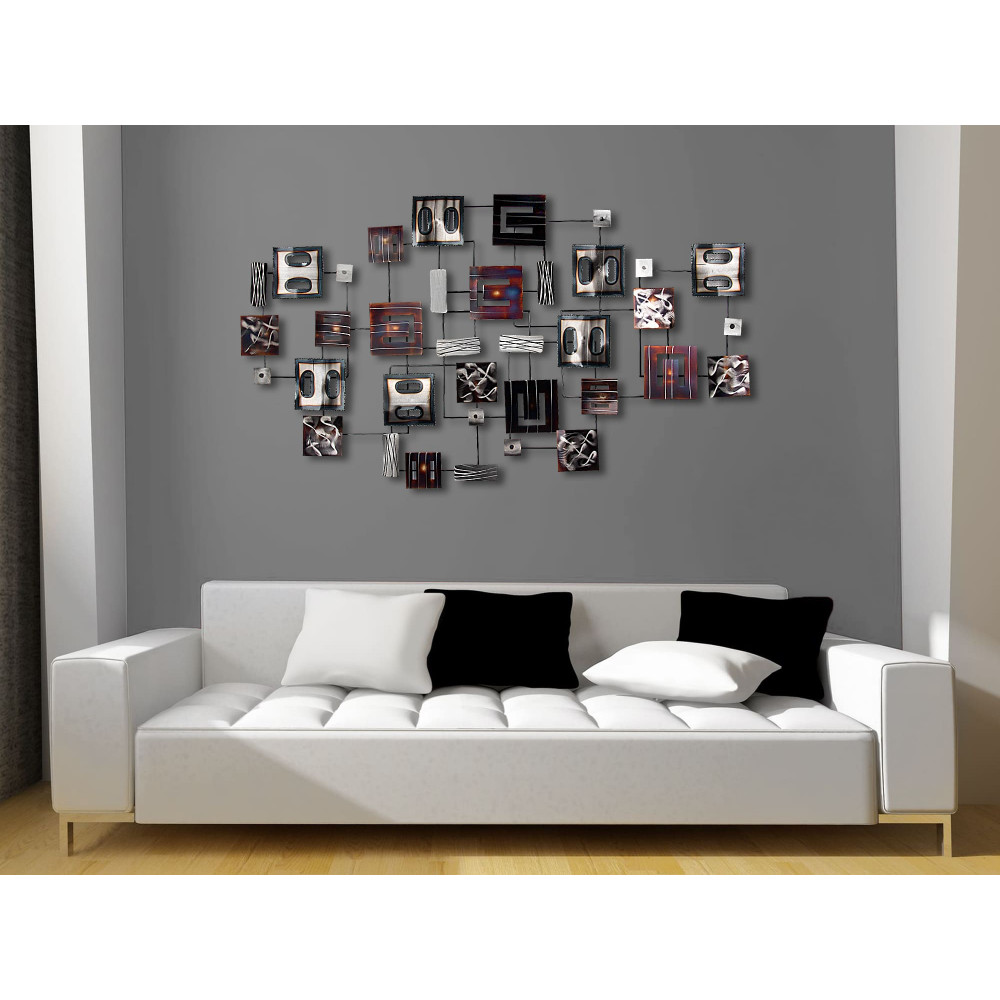 Scultura da parete di metallo appesa su una parete grigia in un salotto di design con un divano bianco