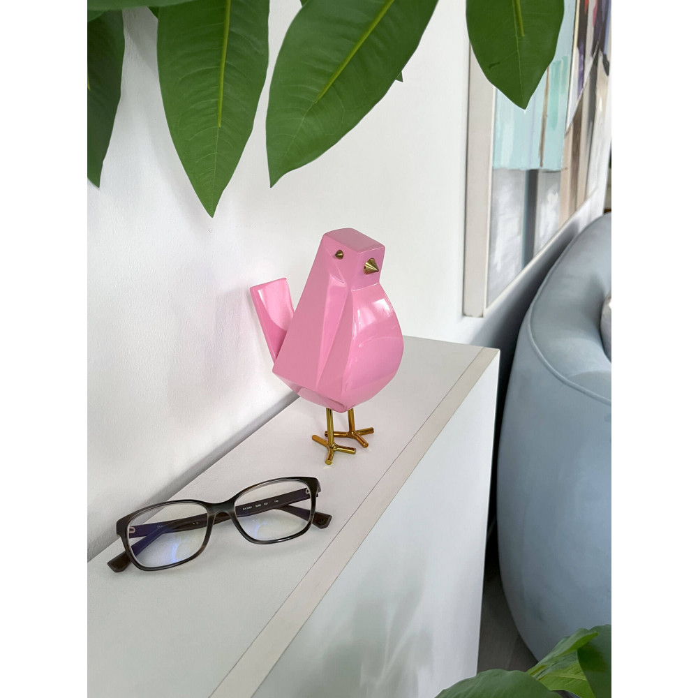 Uccellino rosa in resina su ripiano in legno bianco