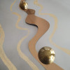 Dettaglio di tondo in metallo raffigurante due semmisfere in oro