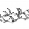 Dettaglio di scultura metallica a muro con ali di gabbiani in tre dimensioni
