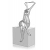Statuetta in resina raffigurante donna con gambe accavallate e braccio portato dietro la nuca