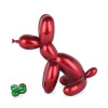 Profilo laterale di statuetta in resina rossa ispirata ad un palloncino modellato come cane con osso verde