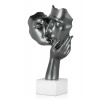 Vista laterale di scultura in resina color grigio scuro laccato rappresentate un bacio