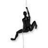 Scultura in resina nera con figura di donna nell'atto di scalare una parete