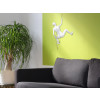 Ambiente living arredato in stile moderno con Scalatrice bianca su parete verde con divano