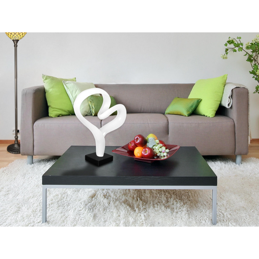 Ambiente living con tavolino decorato con statuetta a forma di cuore bianco in resina su base in marmo