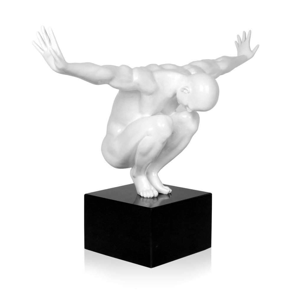 Statua di colore bianco che si chiama Equilibrio che rappresenta una figura umana maschile accovacciata su un piedistallo nero