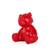 Vista a tre quarti di una scultura in resina rossa laccata rappresentante un peluche