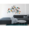 Composizione colorata di cerchi e anelli collocata sulla parete in un ambiente living moderno con divano grigio