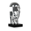 Una statuetta moderna di ispirazione surrealista con volto maschile laccato argento