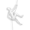 Figura femminile che si arrampica su una parete realizzata in resina bianca laccata