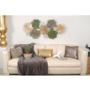 Salotto impreziosito dal quadro in metallo Composizione di foglie stilizzate appeso alla parete bianca sopra divano beige