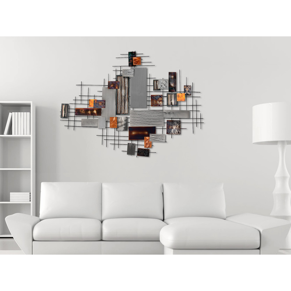 Quadro in metallo con Composizione astratta appeso su parete bianca in un salotto arredato in stile minimal