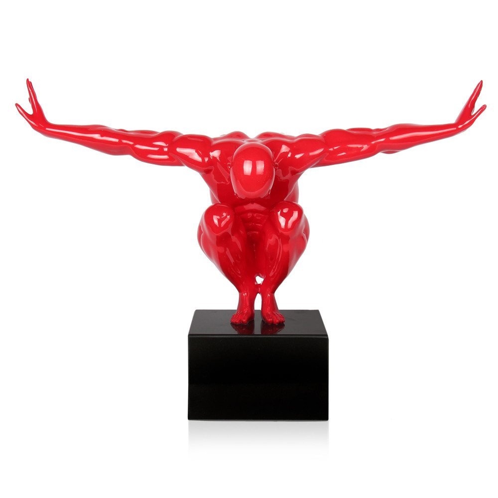 Statuetta figurativa in resina raffigurante un uomo accovacciato con braccia distese in colore rosso brillante