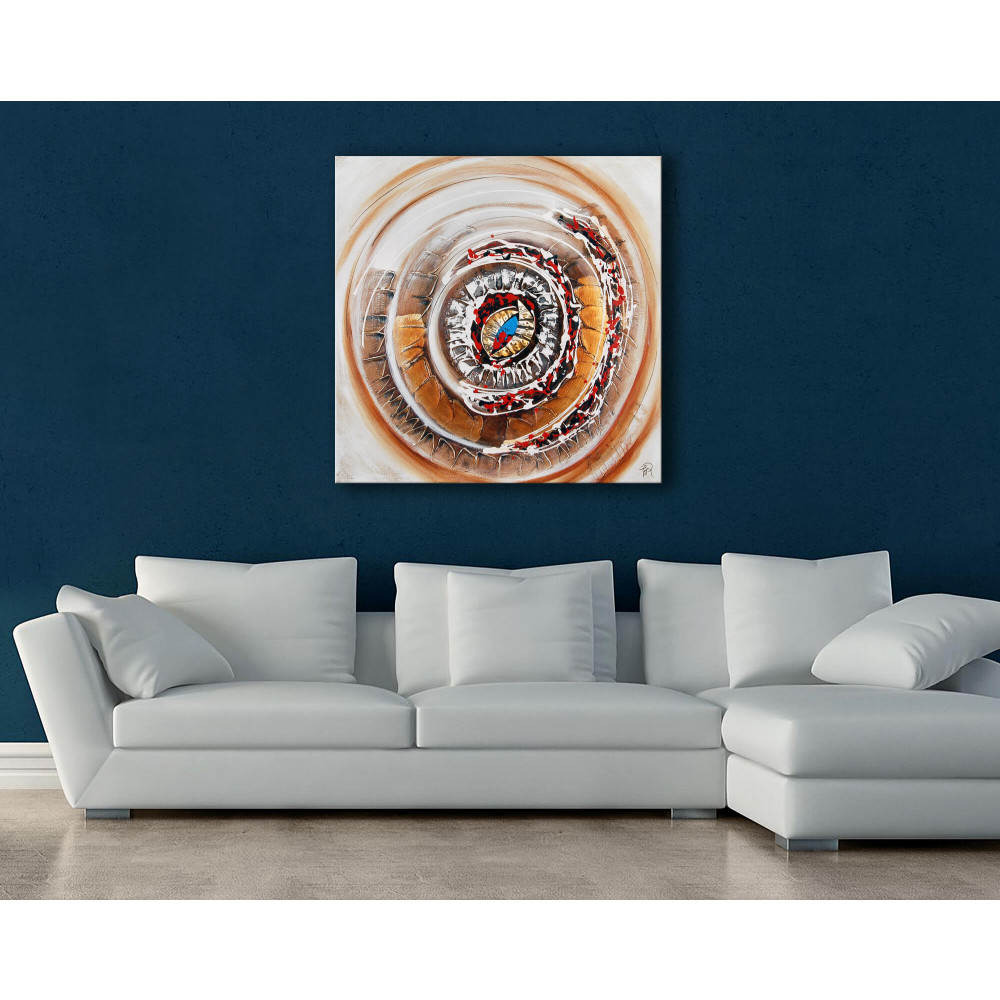 Soggetto astratto con cerchi concentrici in oro e bianco con inserti in metallo posizionato in salotto con divano bianco su parete blu