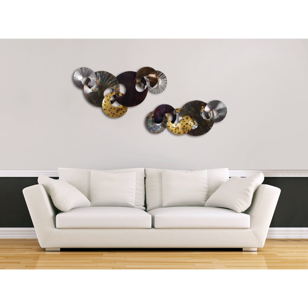 Ambiente living con parete decorata con scultura in metallo formata da cerchi multicolore intersecati
