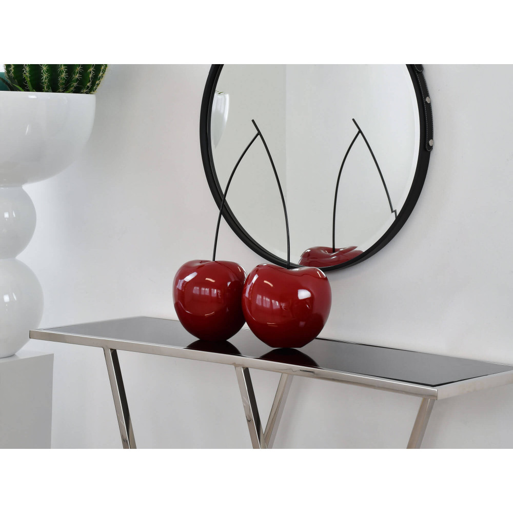Ambiente indoor valorizzato da una coppia di ciliegie rosse laccate su un tavolo