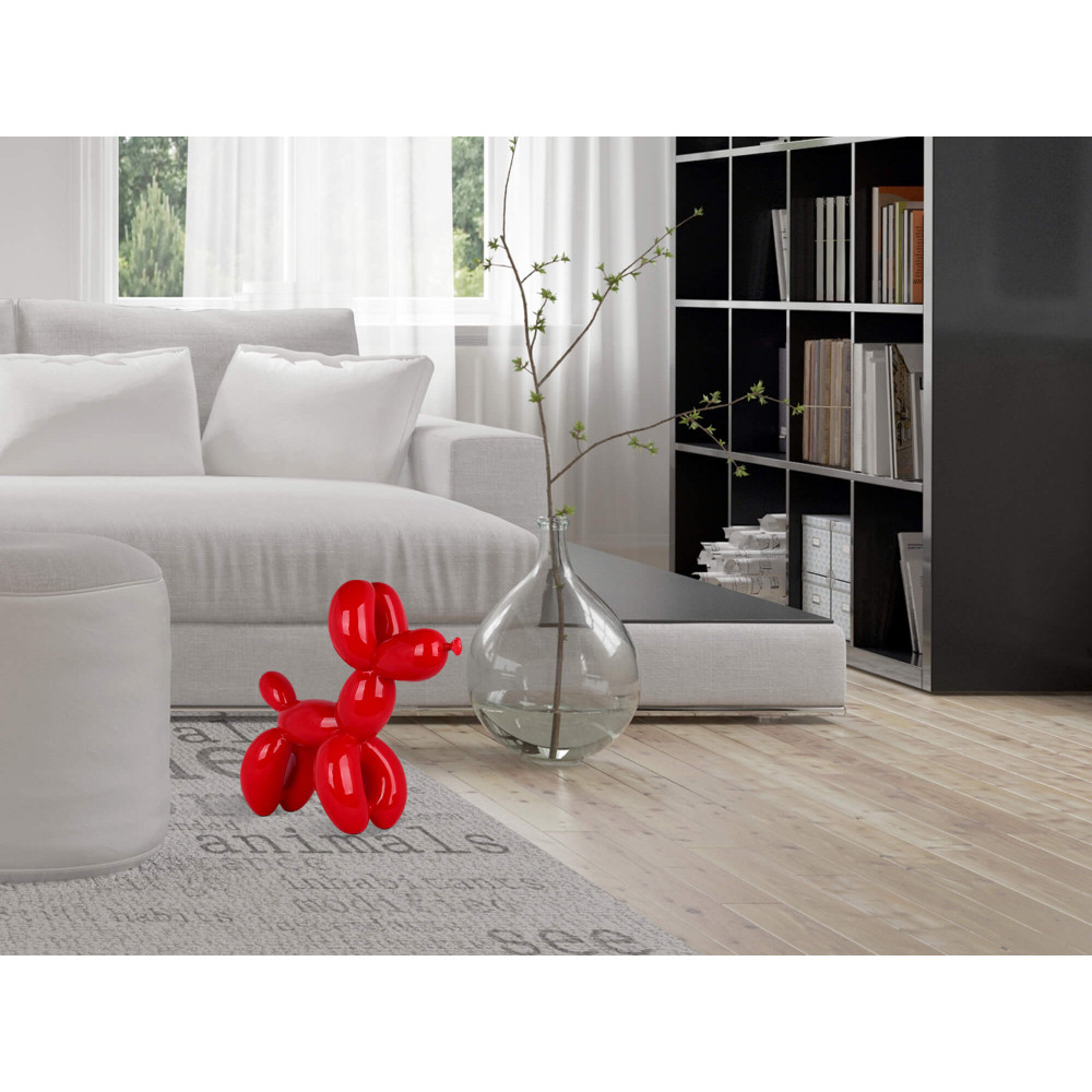 Interno living bianco impreziosito dalla scultura rossa a forma di cane accanto al divano