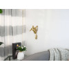 Ambiente living moderno con parete arredata con scultura in resina dorata di corritrice