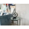 Ambiente living arredato con scultura astratta in resina effetto specchio su tavolino salotto